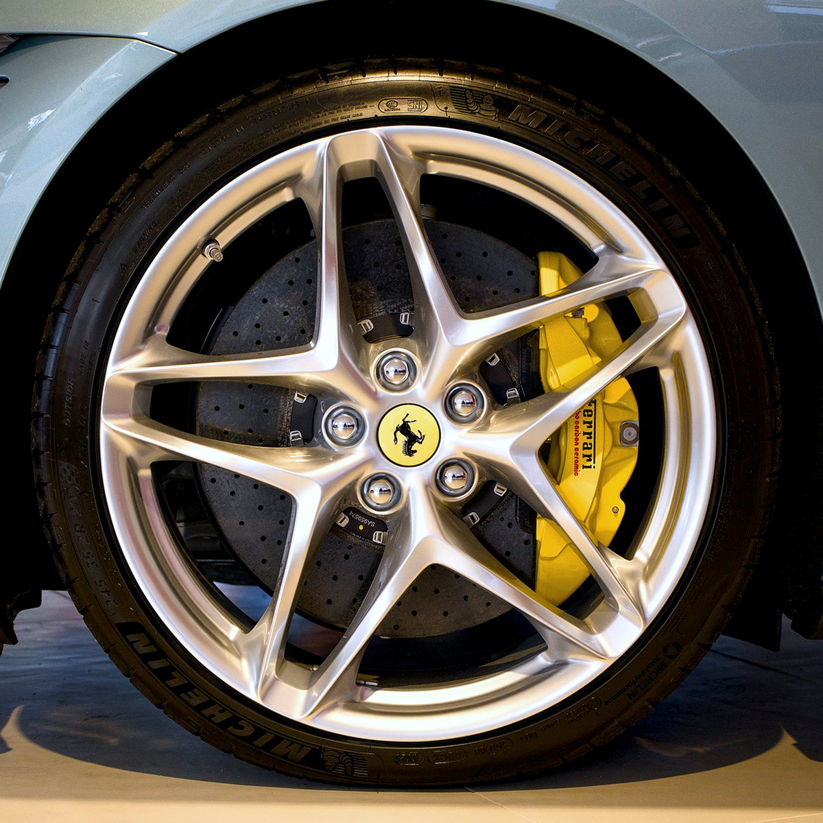 Silver five-spoke alloy with a yellow brake caliper