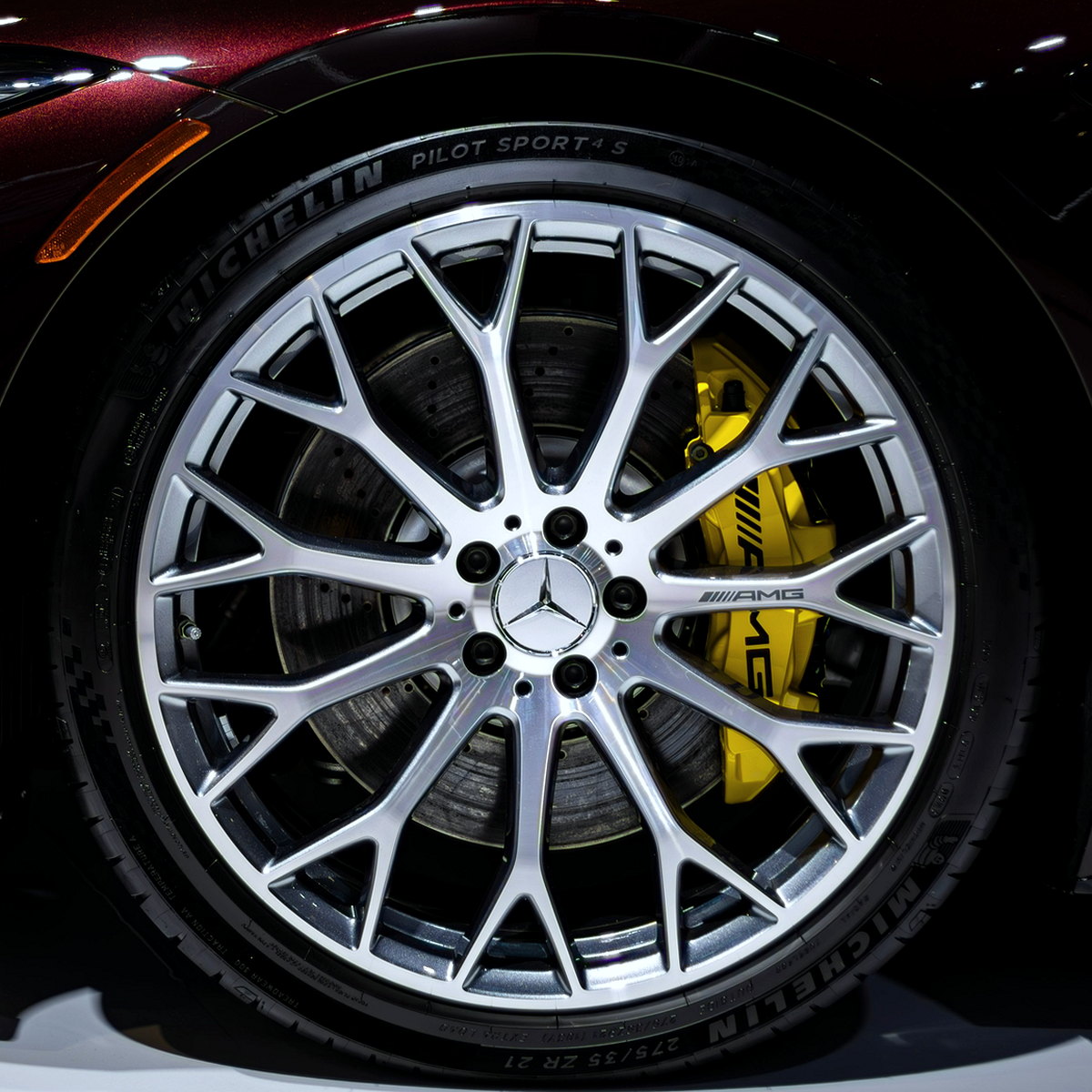 Bright silver multi-spoke alloy with a yellow brake caliper